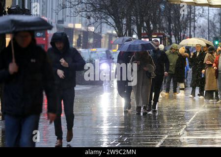 London, UK. 19th Dec, 2023. Shoppers shelter from rain under umbrellas on Oxford Street in central London. (Credit Image: © Steve Taylor/SOPA Images via ZUMA Press Wire) EDITORIAL USAGE ONLY! Not for Commercial USAGE! Stock Photo