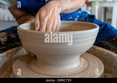 Potter throwing a pot on the wheel in a studio. High quality photo. Hobby, side hustle, activity Stock Photo