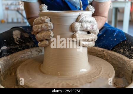 Potter throwing a pot on the wheel in a studio. High quality photo. Hobby, side hustle, activity Stock Photo