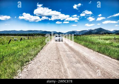 Automobile driving on an unpaved road in the  Rocky Mountains of Montana, USA Stock Photo