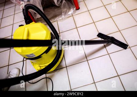 Wardenburg, Germany. 26th Dec, 2023. A young man removes the rising groundwater from a cellar with a vacuum cleaner. The flood situation remains tense in many regions of Lower Saxony over the Christmas holidays. Credit: Hauke-Christian Dittrich/dpa/Alamy Live News Stock Photo