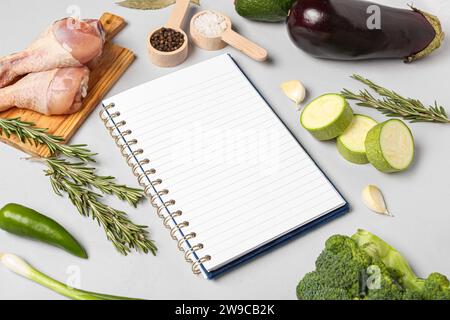 Composition with blank recipe book and different ingredients on grey background Stock Photo