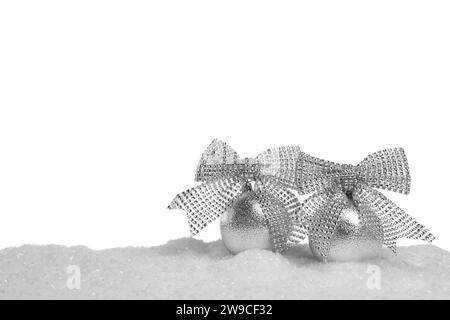 Beautiful silver Christmas balls with bows on snow against white background Stock Photo