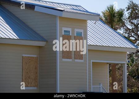 Plywood mounted as storm shutters for hurricane protection of house windows. Protective measures before natural disaster in Florida. Stock Photo