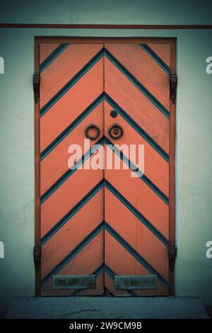 front view closeup of vintage wooden large double barn door with metallic handle and bolts Stock Photo
