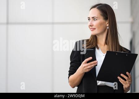 Female office worker just finished phone conversation by office Stock Photo