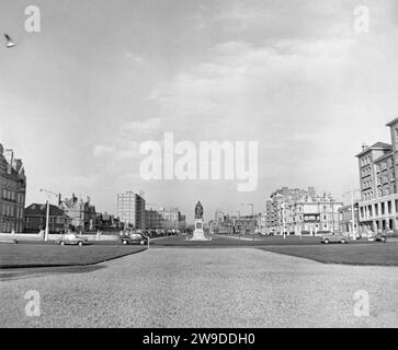 A view from the seafront up a very quiet, relatively car-free Grand Avenue, Hove, Brighton and Hove, East Sussex, England, UK c. 1958. Grand Avenue was designed as the central space of an 1800s development – seafront lawns formed part of the scheme. The 1897 statue of Queen Victoria was erected by to commemorate the 60th anniversary of her reign. The 1874 Princes Hotel, designed by Sir James Knowles is far right. It later became council offices. The houses on the west side of the street (left) have been replaced by blocks of flats and the street now looks very different – a vintage 1950s photo Stock Photo