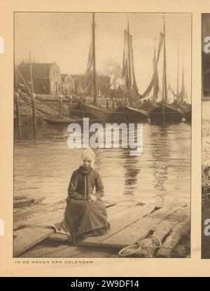 Girl in traditional costumes on the quay in the port of Volendam, Anonymous, in Or Before 1915 photomechanical print This print is part of an album. Volendam paper  girl (child between toddler and youth). folk costume, regional costume. harbour Volendam Stock Photo