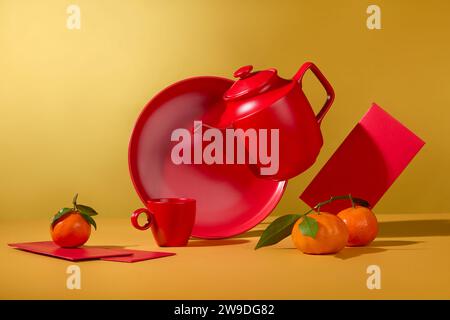 Over yellow background, a tea set in red color decorated with tangerines and few red envelopes. Chinese people consider traditional New Year to be the Stock Photo