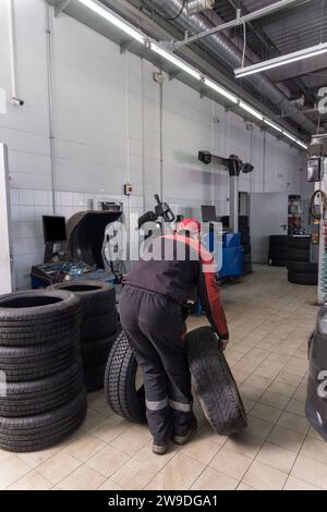 Working inside tire service center. Replacing rubber on car wheels. Car tire service center auto repair workshop. Stock Photo