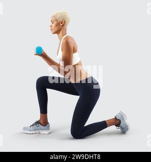 Latin American woman lifts dumbbells, young female athlete doing fitness workout, engaged in physical activity to improve health and fitness. Sportswo Stock Photo