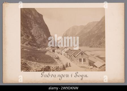 Gudvangen in Sogn, Noorwegen, c. 1870 - c. 1900 photograph Drive houses along a road and between steep rock walls on the left and a more right. On the road are three women in dark clothing. Gudvangen is a village in the municipality of Aurland in the province of Sogn Og Fjordane in Norway. Norway photographic support. cardboard albumen print  Norway Stock Photo