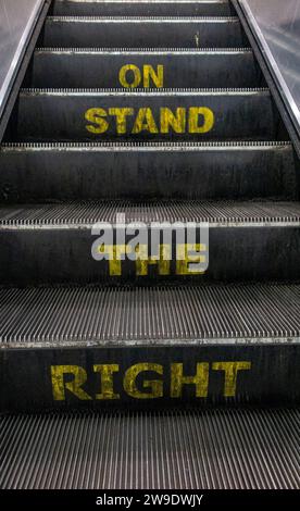 Jumbled worrds on an escalator, which should spell "Stand on the right" Stock Photo