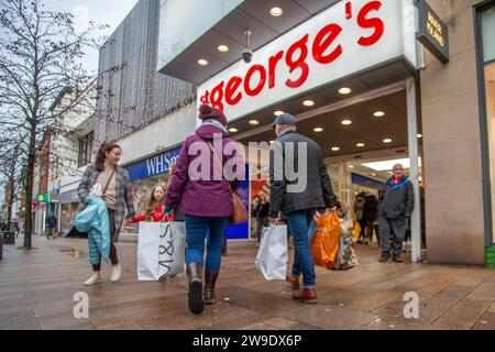 Preston, Lancashire.  UK Weather. 27 Dec 2023. Christmas Sales shops, shoppers shopping on a wet and gusty day in the city centre. Credit MediaWorldImages/AlamyLiveNews Stock Photo