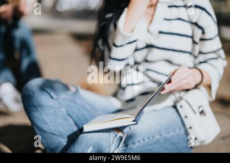 Diverse college students collaborating outdoors, discussing subjects, achieving goals, and preparing for exams. Stock Photo