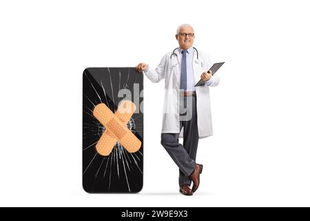 Doctor with a broken smartphone and bandage on a cracked screen isolated on white background Stock Photo