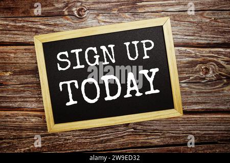 Sign up todaywrite on blackboard top view on wooden background Stock Photo