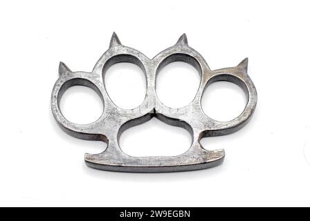 Old metal brass knuckles knuckledusters with spikes isolated on white background injuries, street fights, fights without rules, urban crime. German Wo Stock Photo