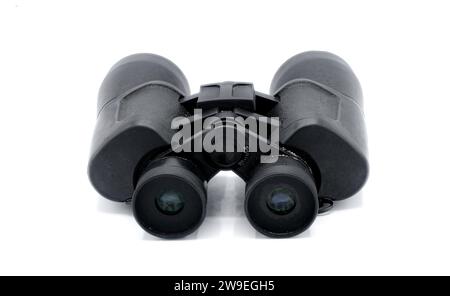 A pair of black rubber grip metal binoculars isolated on white background.  Well worn, used, dirty full of sand from being out in the field viewing wi Stock Photo