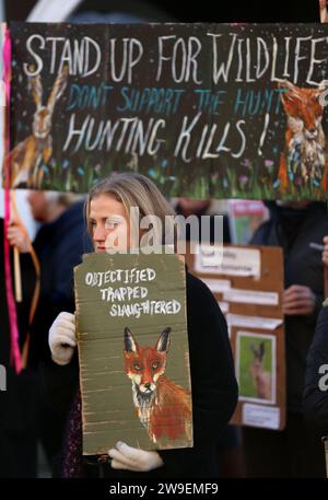 Bungay, Suffolk, UK. 26th Dec, 2023. Protesters stand with a banner urging people to not support the hunt and one holds a sign saying ''˜Objectified, Trapped' Slaughtered' with a picture of a fox during the demonstration. Action Against Animal Cruelty, protest was held in the town centre, Bungay as the Waveney and Norfolk Harriers parade through the streets supporting the countryfolk. The protesters said that despite their being a ban on traditional fox hunting, animals are still being killed during the trail hunting alternative and they are calling for a total ban. (Credit Stock Photo