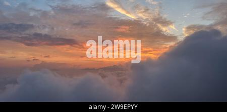 An idyllic landscape featuring the setting sun illuminated by a beautiful sky of fluffy clouds Stock Photo