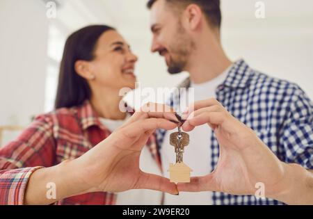 Happy loving family couple holding house keys and making heart shape with their hands Stock Photo