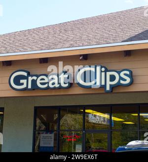 Great Clips hair salon Exterior facade sign signage above entrance in strip mall haircut location. They provide haircuts to men, women and kids. Blue Stock Photo