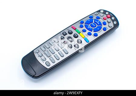 Black and silver remote control for tv, satellite, dvd, auxiliary, DVR or media center, with multiple color red, blue, yellow, green buttons on a whit Stock Photo