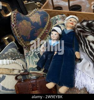 Two early twentieth century rag dolls dressed as sailors among clothes at an antique market Stock Photo