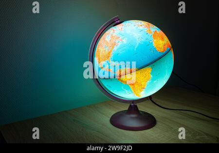 Illuminated globe showing oceans and continents with bright colors. Stock Photo