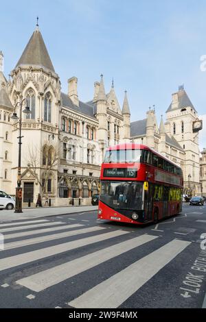 London, UK - March 16 2023; Red double decker bus passing Royal Courts of Justice building Stock Photo