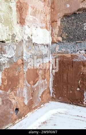 Damaged damp plaster exposing brick in a bathroom. Home improvement problems concept Stock Photo