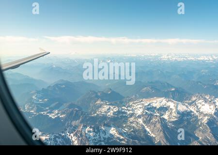 Stunning view of Mount Baker in the distance, framed by a plane window against a vast mountainous landscape. Stock Photo