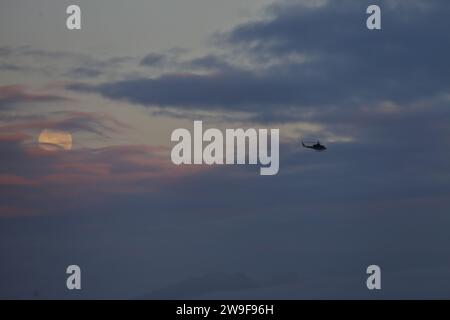 Bogota, Colombia. 27th Dec, 2023. General view of the last full moon of 2023, also known as the Cold Moon, is seen through the clouds at dawn over the city of Bogota. on December 27, 2023 in Bogota, Colombia. (Credit Image: © José Isaac Bula Urrutia/eyepix via ZUMA Press Wire) EDITORIAL USAGE ONLY! Not for Commercial USAGE! Stock Photo