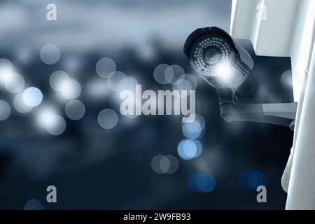 Modern security CCTV camera on building wall outdoors, space for text Stock Photo