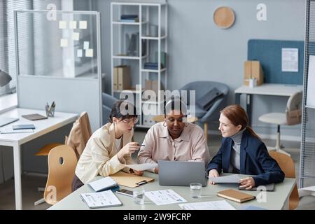 Three Female Colleagues Working on Business Report Stock Photo