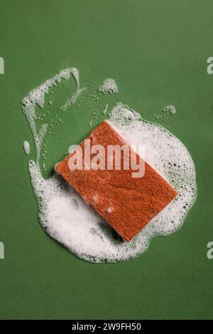 Coconut Biodegradable sponge and foam on green background, eco cleaning tools Stock Photo