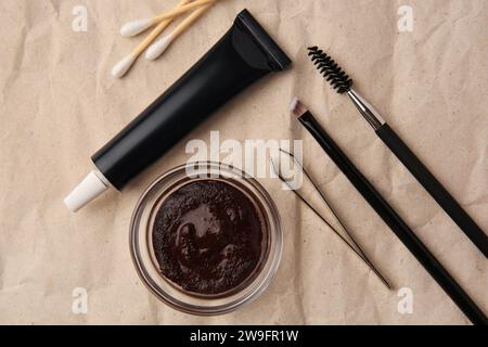 Flat lay composition with eyebrow henna and tools on crumpled paper Stock Photo