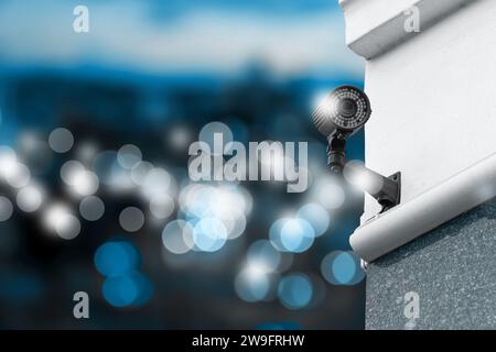 Modern security CCTV camera on building wall outdoors, space for text Stock Photo