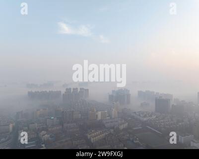 HUAI'AN, CHINA - DECEMBER 28, 2023 - Buildings loom in thick fog in Huai 'an city, East China's Jiangsu province, Dec 28, 2023. Stock Photo