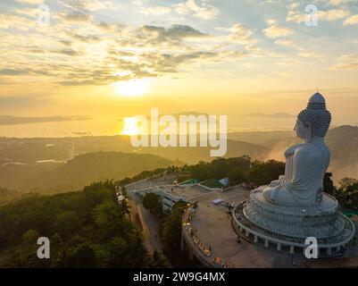 Aerial view The golden sun shines through the clouds above the ocean at the Big Buddha.  bright yellow sun ray shine on the head of Phuket big Buddha. Stock Photo