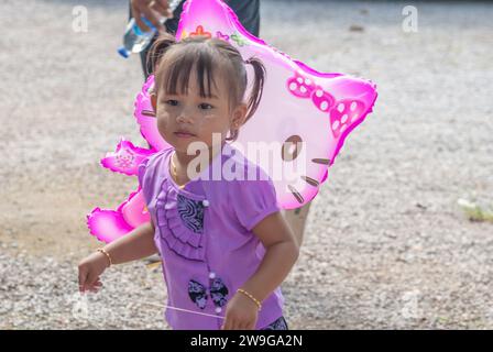 SURATTANI, THAILAND -NOV. 06, 2023: Young Burmese child is having fun at the Kathina merit-making festival of Burmese brothers and sisters living in T Stock Photo