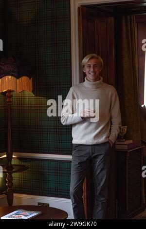 Stylish handsome young caucasian man enjoying whiskey in an elegant room. Stock Photo
