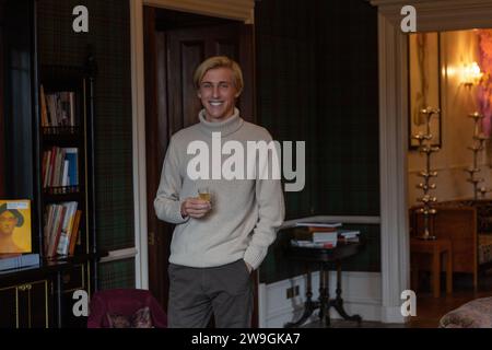 Stylish handsome young caucasian man enjoying whiskey in an elegant room. Stock Photo