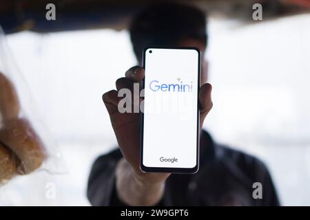 Dhaka, Bangladesh - 27 December 2023: Hand holding a phone with Google Gemini AI chatbot Gemini is a family of multimodal large language models develo Stock Photo