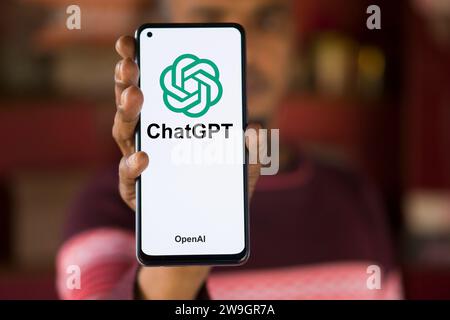Dhaka, Bangladesh - 27 December 2023: Hand holding a phone with ChatGPT AI chatbot. ChatGPT is a chatbot developed by OpenAI. Stock Photo