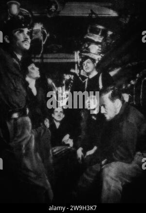 The concern on faces of a German U-Boat crew as they wait depth charges dropped from a destroyer on Atlantic convoy escort duties in February 1943, during the Second World War. Stock Photo