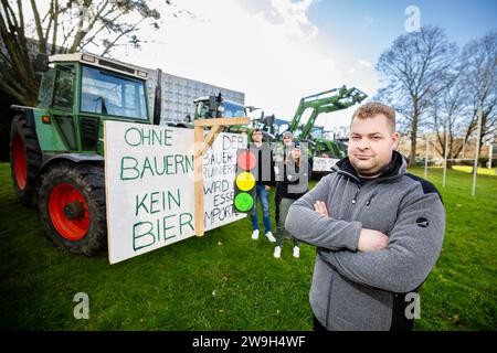 Kassel, Germany, 28. December 2023, In the front René Riede (29, employed farmer from Espenau), in the back from left Luc (18) with his sister Leonie Nutschan (21, family farm in Espenau) and Joris Swatzki (22, Vellmar), Around 100 farmers from northern Hesse demonstrated in Kassel city centre on Thursday (28 December) against the government's plans. After a tractor convoy around the city centre, more than 60 tractors parked in front of the Kassel Regional Council. The farmers then met in front of Kassel's town hall to talk to the public. Farmer Marc Sprenger (49, Staufenberg-Escherode): 'If t Stock Photo