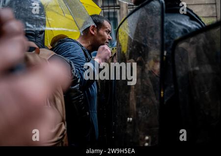 A protester chants slogans in front of the police during the demonstration. 'Yellow vests” (gilets jaunes) anti-government protesters gathered in Paris on their 5th anniversary of the movement to show the government that they are still alive and over the years they have increased in number. Stock Photo