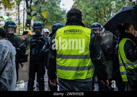 A 'yellow vest' anti-government protester chants slogans in front of the police during the demonstration. 'Yellow vests” (gilets jaunes) anti-government protesters gathered in Paris on their 5th anniversary of the movement to show the government that they are still alive and over the years they have increased in number. Stock Photo